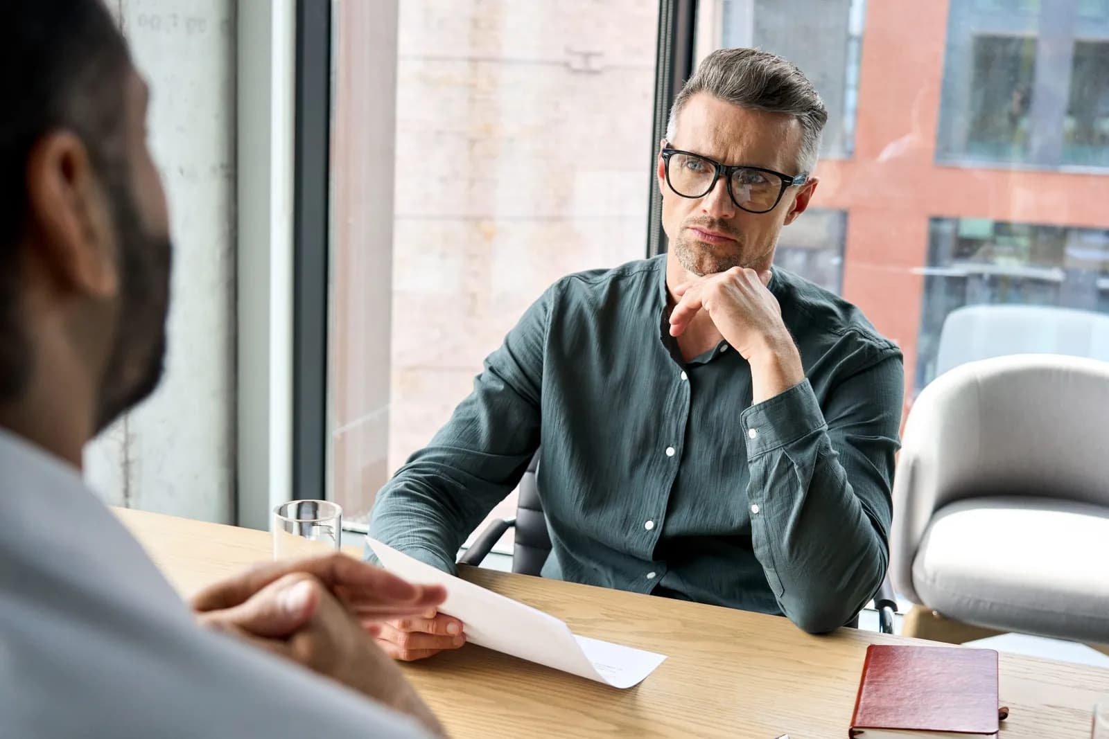 Consultant reviewing a contract with a physician across a desk